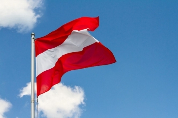 &Ouml;sterreich-Fahne vor blauem Himmel mit kleinen Wolken